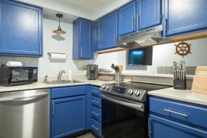 cocina azul con fregadero y fogones en Aurora at Nautilus - Pet Friendly Oceanfront Condo en Ocean Shores
