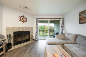 a living room with a couch and a fireplace at Aurora at Nautilus - Pet Friendly Oceanfront Condo in Ocean Shores
