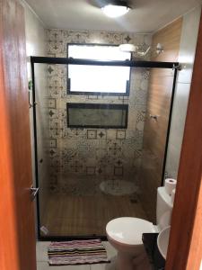 une salle de bain avec douche, toilettes et fenêtre dans l'établissement Três Marias Chalés, à Conceição da Ibitipoca