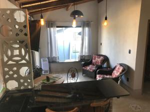 un salon avec deux chaises et un miroir dans l'établissement Três Marias Chalés, à Conceição da Ibitipoca