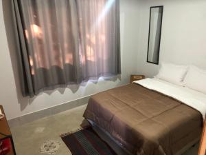 une chambre avec un lit et une fenêtre dans l'établissement Três Marias Chalés, à Conceição da Ibitipoca