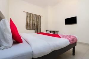 a bedroom with a bed with red and white pillows at OYO Hotel Shiv Shakti Inn Near Kamal Cinema in New Delhi