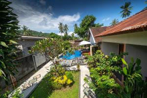 a view of the backyard of a house with a swimming pool at Family Garden Homestay in Senggigi 
