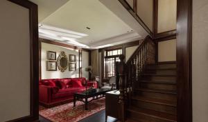 a living room with a red couch and stairs at Hangzhou Qiushui Villa in Hangzhou