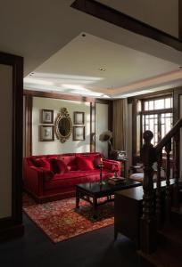 a living room with a red couch and a table at Hangzhou Qiushui Villa in Hangzhou