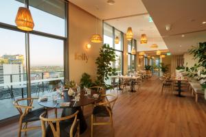 un ristorante con tavoli, sedie e ampie finestre di Quest East Perth a Perth