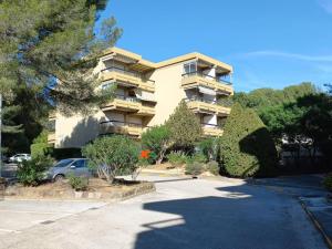 un immeuble avec une voiture garée devant lui dans l'établissement Appartement Bormes-les-Mimosas, 1 pièce, 3 personnes - FR-1-610-85, à Bormes-les-Mimosas