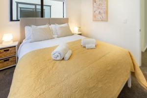 een slaapkamer met een groot bed en handdoeken bij Inner City Luxury 2 Bedroom 2 Bathroom in Christchurch