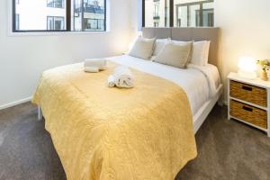 Un dormitorio con una cama grande con una manta amarilla. en Inner City Luxury 2 Bedroom 2 Bathroom, en Christchurch 27 fotos más