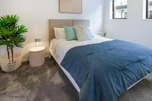 Un dormitorio con una cama grande con una manta azul. en Inner City Luxury 2 Bedroom 2 Bathroom, en Christchurch