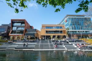 Un grupo de personas sentadas en los escalones frente a los edificios. en Inner City Luxury 2 Bedroom 2 Bathroom, en Christchurch