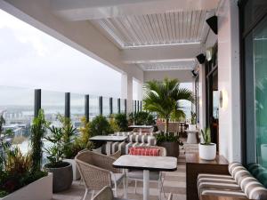 an outdoor patio with tables and chairs and plants at Sudima Auckland City in Auckland