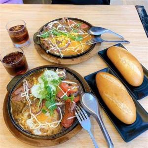 una mesa de madera con dos platos de comida. en Thuy Loi Hotel, en Hoi An