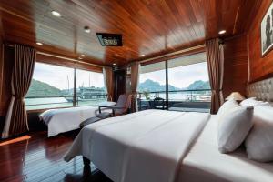 a bedroom with two beds and a balcony on a boat at Blue Diamond Cruise in Ha Long +47 photos
