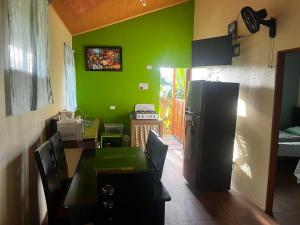 a kitchen with a table and a green wall at El Buda in Poás