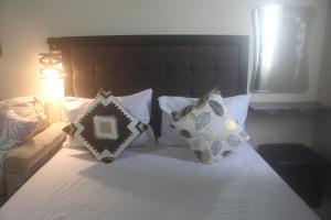 a bedroom with a bed with pillows on it at Avida Tower 2 Mountain View Condominium in Davao City