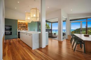 a kitchen and dining room with a table and a dining room at Elouera in Byron Bay