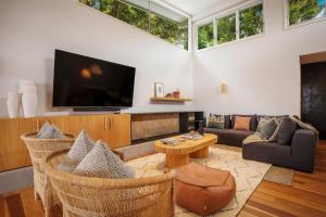 a living room with a flat screen tv and a couch at Elouera in Byron Bay