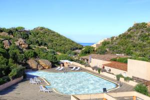 a swimming pool with chairs and a mountain at Paradiso Pool Apartments by DomusAway in Costa Paradiso