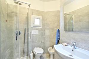 a bathroom with a shower and a toilet and a sink at Paradiso Pool Apartments by DomusAway in Costa Paradiso