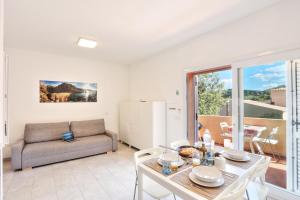 a living room with a table and a couch at Paradiso Pool Apartments by DomusAway in Costa Paradiso