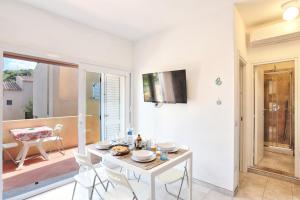 a white dining room with a table and chairs at Paradiso Pool Apartments by DomusAway in Costa Paradiso +31 photos
