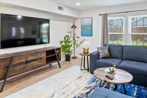 sala de estar con sofá azul y TV grande en LUCKY House - Tranquility in the Middle of Houston - TV in every room - 300 m2 en Houston