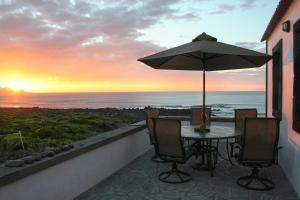 einen Tisch mit Sonnenschirm auf einem Balkon mit Meerblick in der Unterkunft Dream By The Sea in Madalena