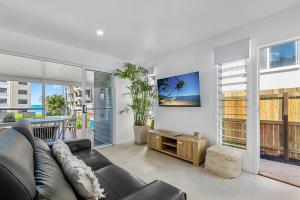 a living room with a black couch and a table at Luxury Coastal Retreat in Coolum Beach