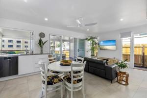 a kitchen and living room with a table and a couch at Luxury Coastal Retreat in Coolum Beach