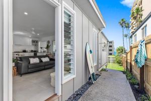 - un salon avec un canapé et une planche de surf dans une maison dans l'établissement Luxury Coastal Retreat, à Coolum Beach