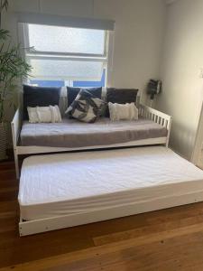 two beds in a room with a window at Luxury Coastal Retreat in Coolum Beach