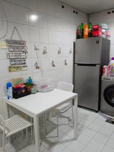 a kitchen with a white table and a refrigerator at Affordable transient - not a hotel - sharing kitchen and washrooms in Abu Dhabi
