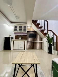 una cocina con una mesa de madera y una escalera en Z House of Guest- Airport Davao, en Davao City