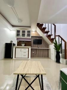 a kitchen with a wooden table and a staircase at Z House of Guest- Airport Davao in Davao City