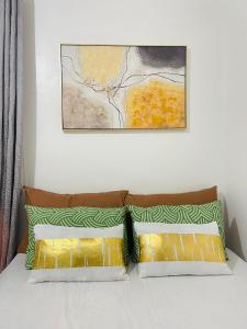 a bed with two pillows and a painting above it at Z House of Guest- Airport Davao in Davao City