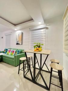 a living room with a table and a green couch at Z House of Guest- Airport Davao in Davao City