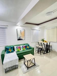 a living room with a green couch and a table at Z House of Guest- Airport Davao in Davao City