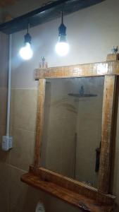 a mirror in a bathroom with two lights above it at Lo de La Abuela 1 in Goya