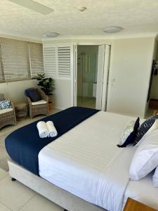 a large bed with two pillows on it in a bedroom at Two Bedroom Ocean View Penthouse at Pelican Sands in Gold Coast