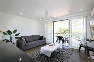 a living room with a couch and a table at CBD apartment Cairns waterfront in Cairns