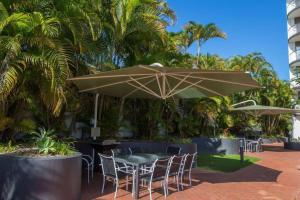 a table and chairs under an umbrella on a patio at CBD apartment Cairns waterfront in Cairns
