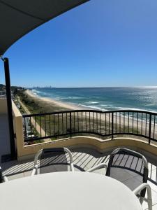 balcón con mesa, sillas y vistas al océano en Two Bedroom Ocean View Penthouse at Pelican Sands en Gold Coast