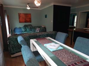 Daintree Rainforest Accommodation في Cow Bay: غرفة معيشة مع أريكة وطاولة