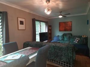a bedroom with a bed and a table with chairs at Daintree Rainforest Accommodation in Cow Bay