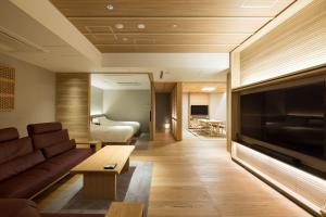 uma sala de estar com um sofá e uma televisão de ecrã plano em Kinzan em Kobe