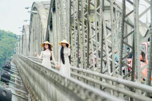 Due donne in cappello in piedi su un ponte di Casablanca Hotel a Hue