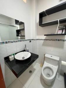 a bathroom with a white toilet and a sink at Moderna casa con equipamiento completo! in Ica