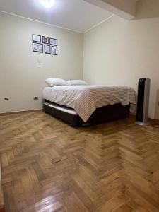 a bedroom with a bed and a wooden floor at Moderna casa con equipamiento completo! in Ica