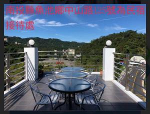 een balkon met een tafel en stoelen bij Mei Jen house B&B 日月潭民宿 in Yuchi